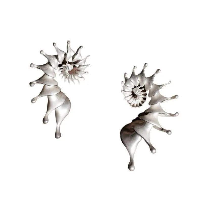 Exaggerated three-dimensional matte conch stud earrings in an alloy with an electroplated finish.