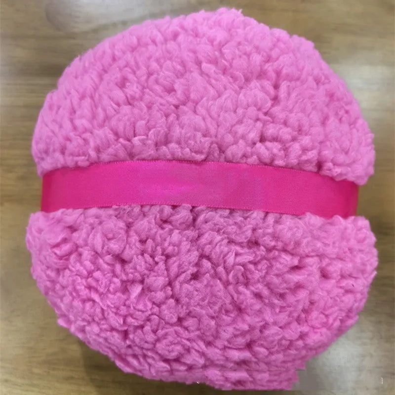 Oversized rectangular plush powder puff in white on a pink background.