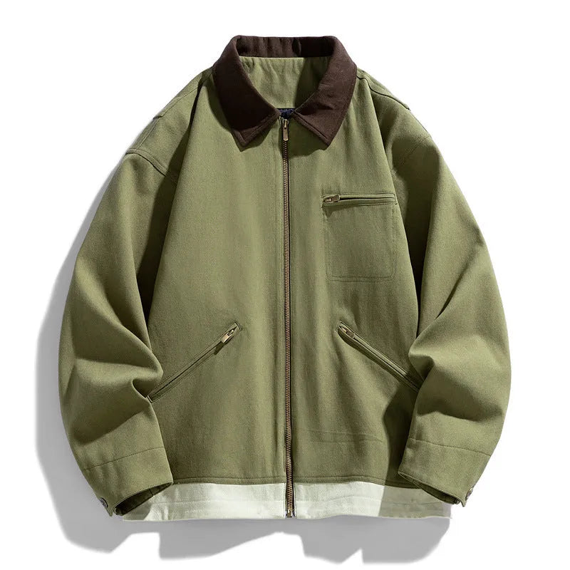 Man wearing a mint green loose-fit retro workwear jacket with dark contrast lapels and side seam pockets.