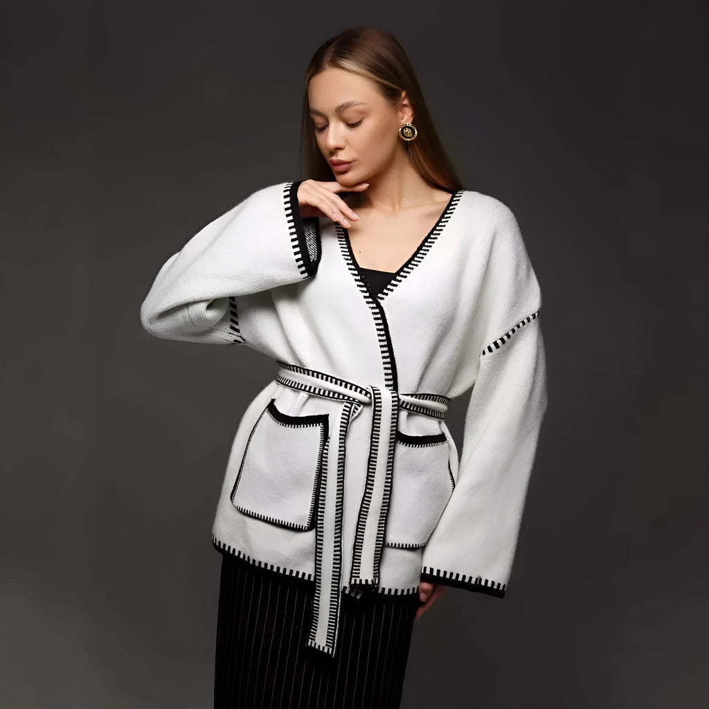 Loose fit camel coloured knitted cardigan sweater with long sleeves laid flat.