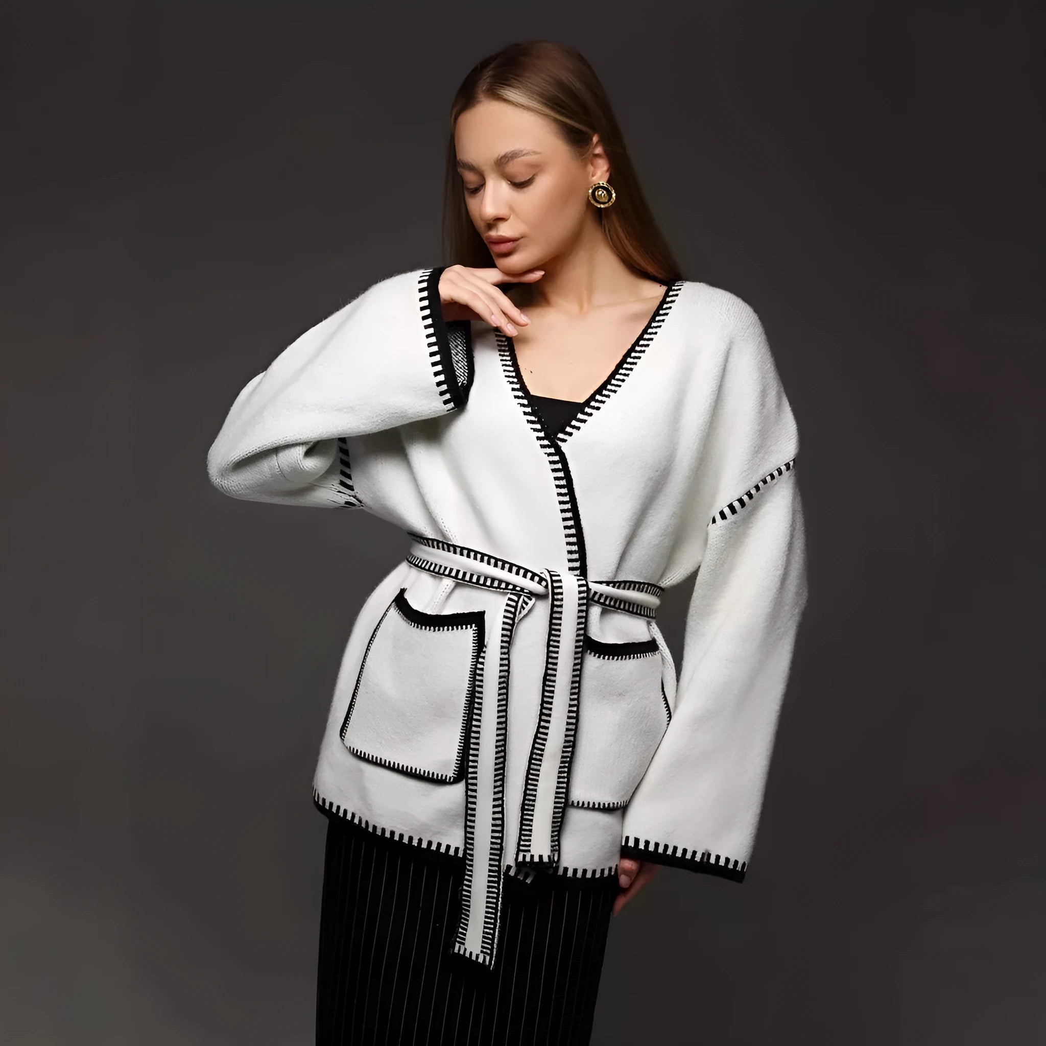 Loose fit camel coloured knitted cardigan sweater with long sleeves laid flat.