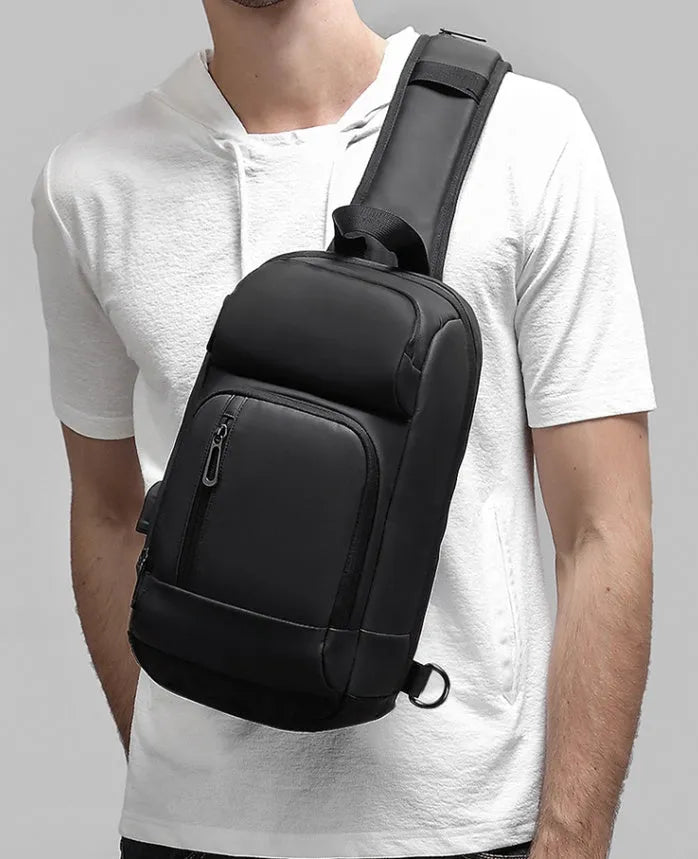 Black PVC medium shoulder bag with multiple internal compartments and adjustable strap