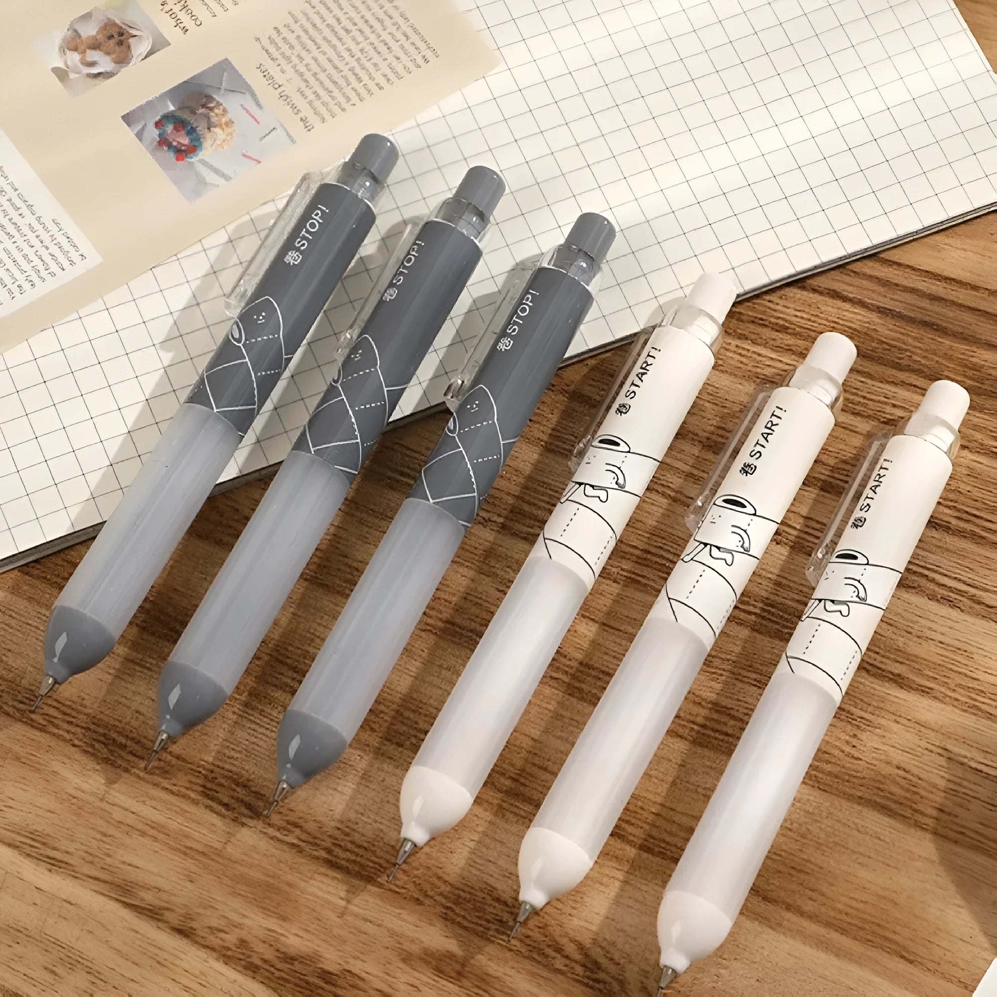 Black and white 0.5mm mechanical pencils with Cloud Grip, HB lead, on a minimalist background.
