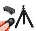 Black flexible octopus tripod with bent legs wrapped around a pole, showing smartphone mount with 1/4-20 screw.