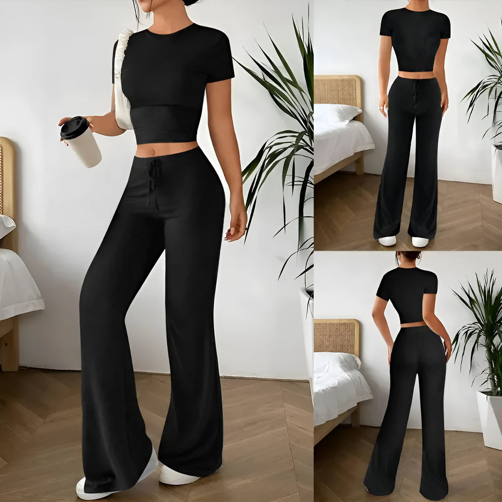 Black women's high waist trousers and short sleeve t-shirt co-ord set laid flat.