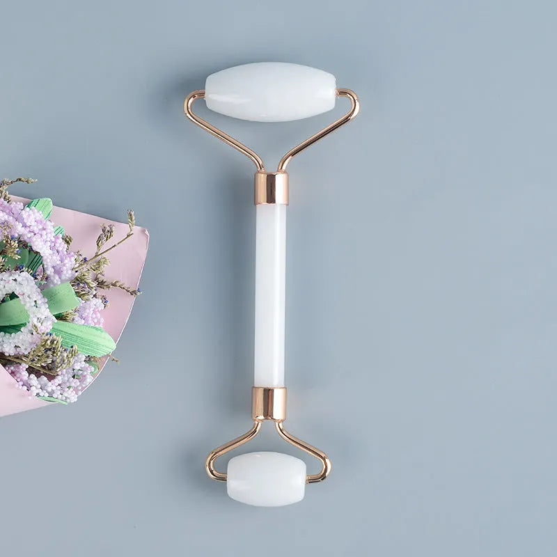 White jade double-headed facial roller and gua sha scraping tool set with a wooden storage board.