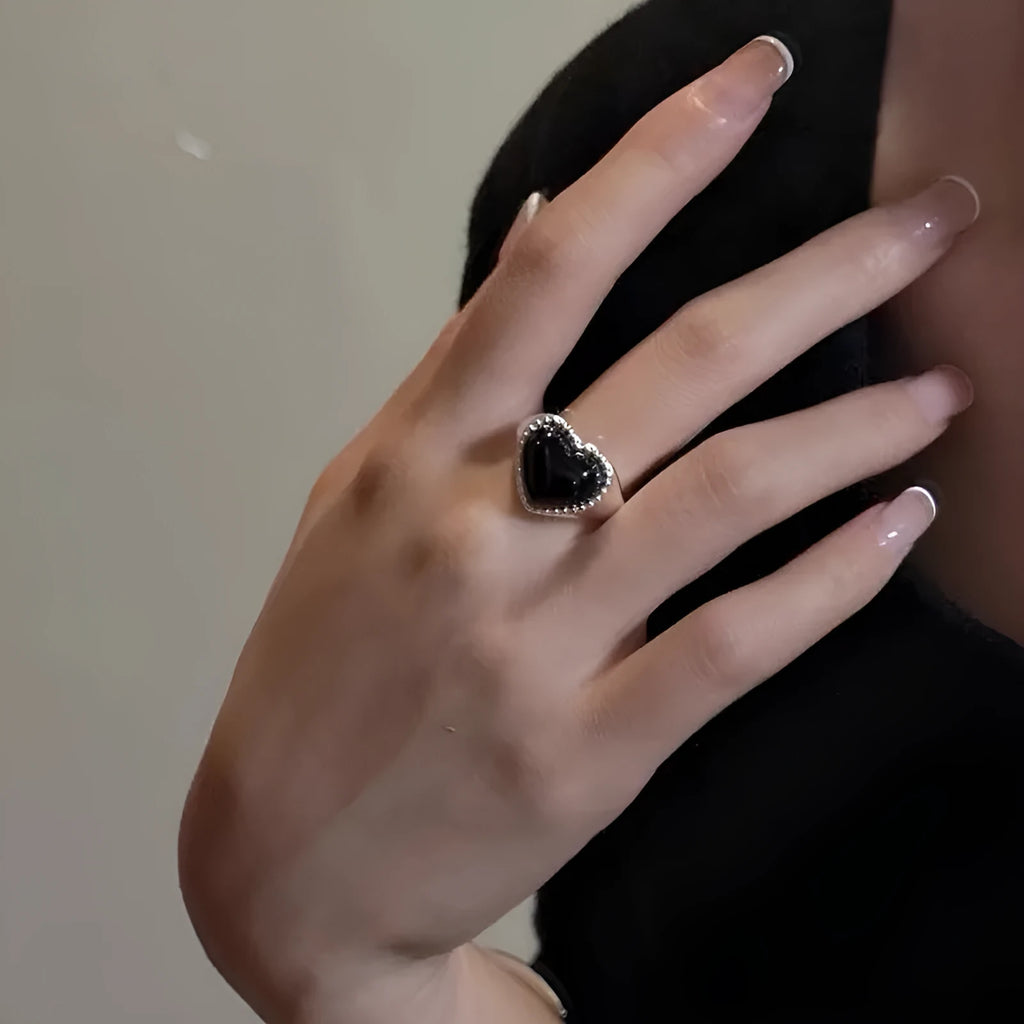 S925 sterling silver adjustable ring with a black agate heart design on a finger.