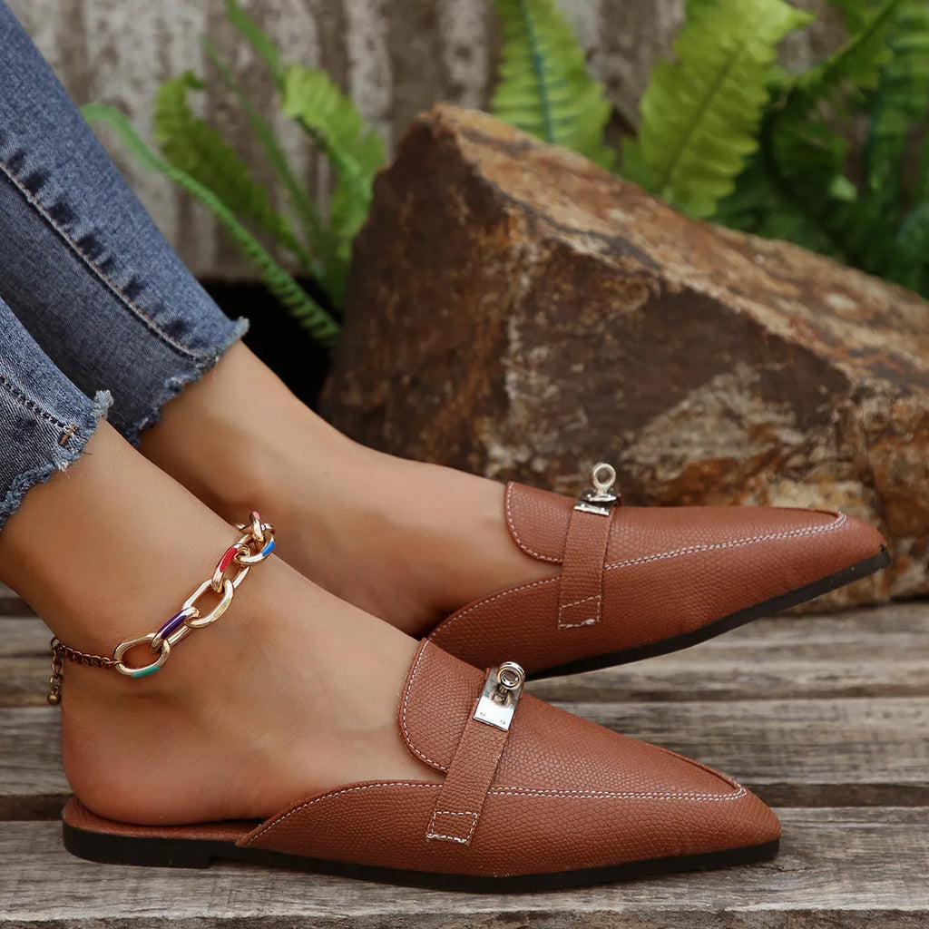 Light brown women's pointed toe low heel slippers with a rubber sole on a plain background.