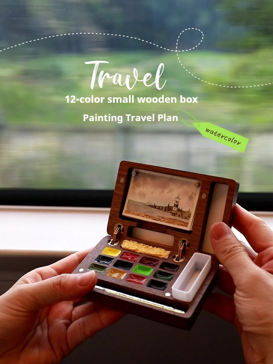 Miniature walnut wood watercolour paint box open to show pigment pans and wooden palette