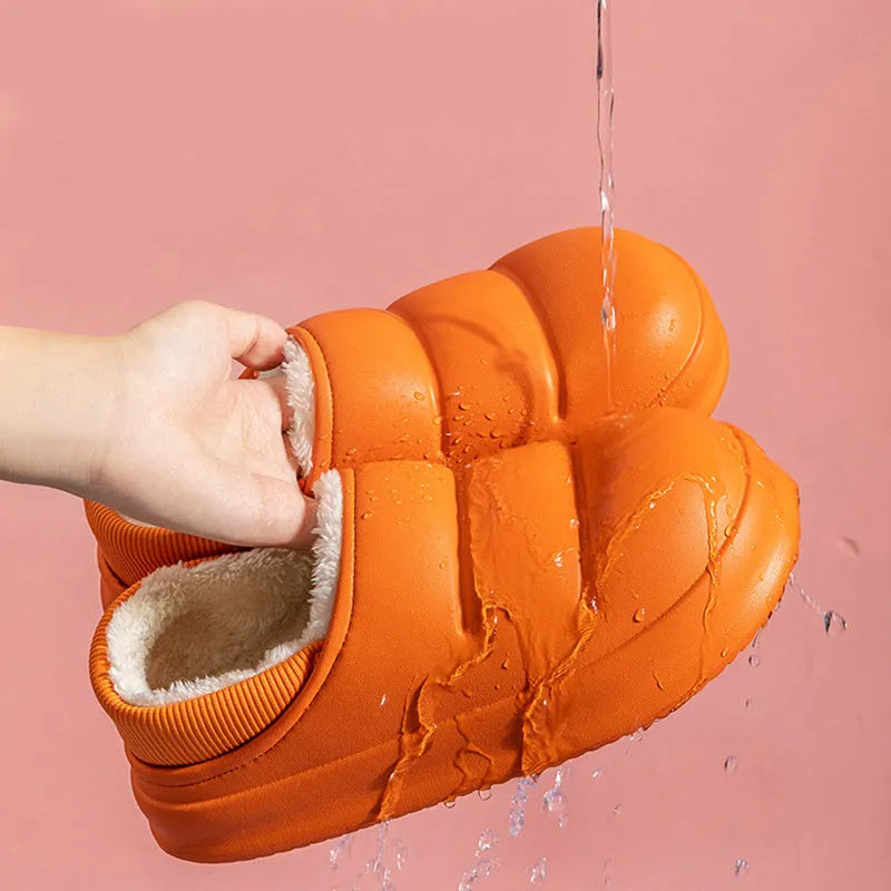 Green waterproof EVA garden slippers with plush lining and a non-slip sole, shown on a wooden deck.