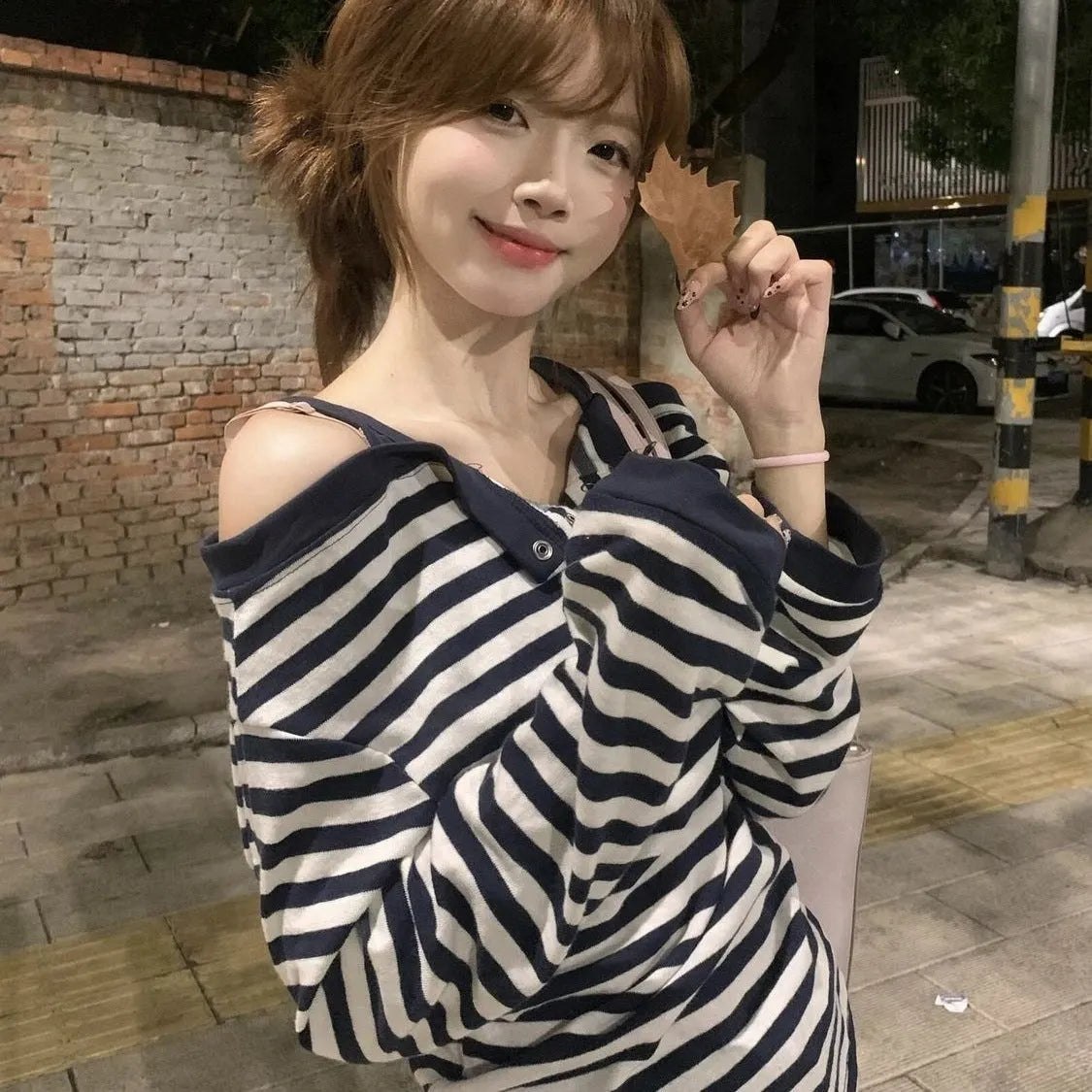 Dark blue oversized women's long-sleeve t-shirt with stripes, button detail, and embroidery on the front.