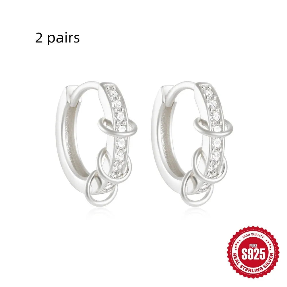 A pair of small, round, geometric stud earrings made of sterling silver with an electroplated finish.