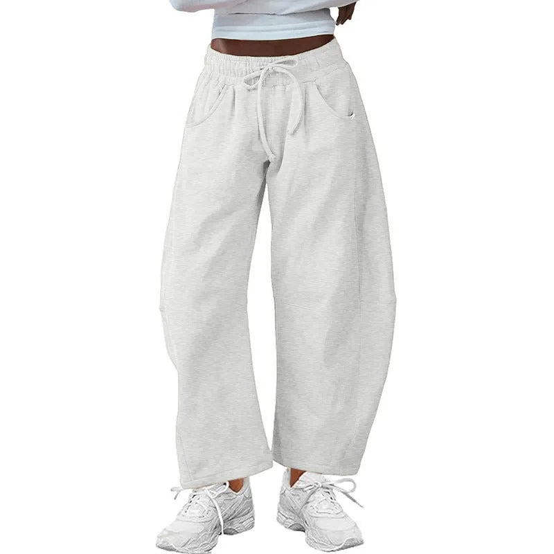 Loose grey cropped sweatpants with elastic drawstring waist and pockets on a mannequin