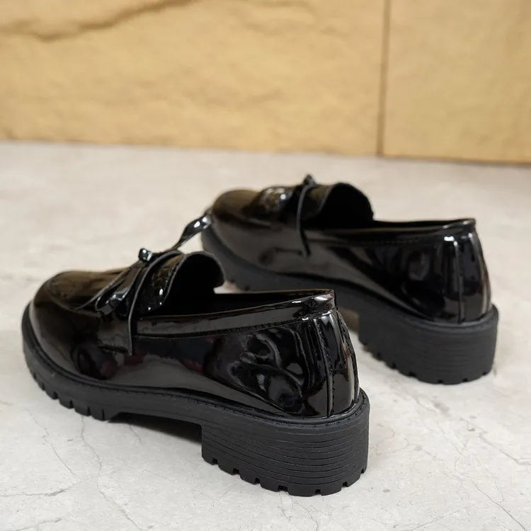 Brown women's slip-on loafers with a black bow detail on the front.