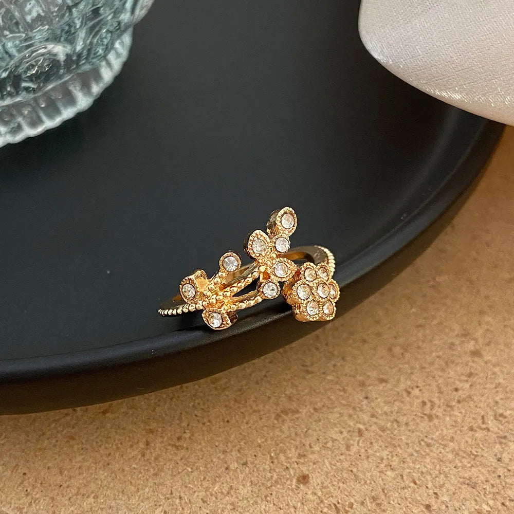 Open mouth copper ring with flower and leaf design in a gold finish