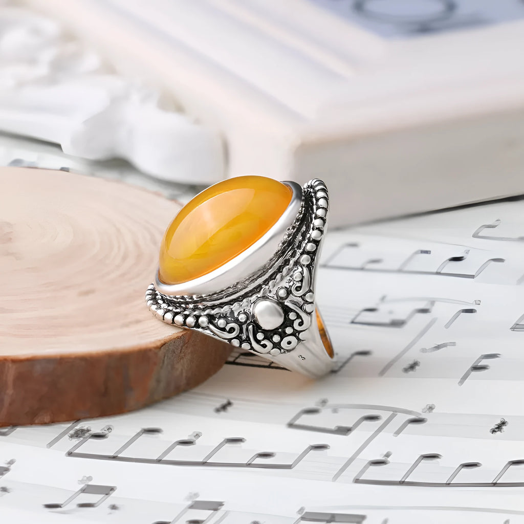 Geometric alloy ring with antique silver amber electroplated finish on a grey background.
