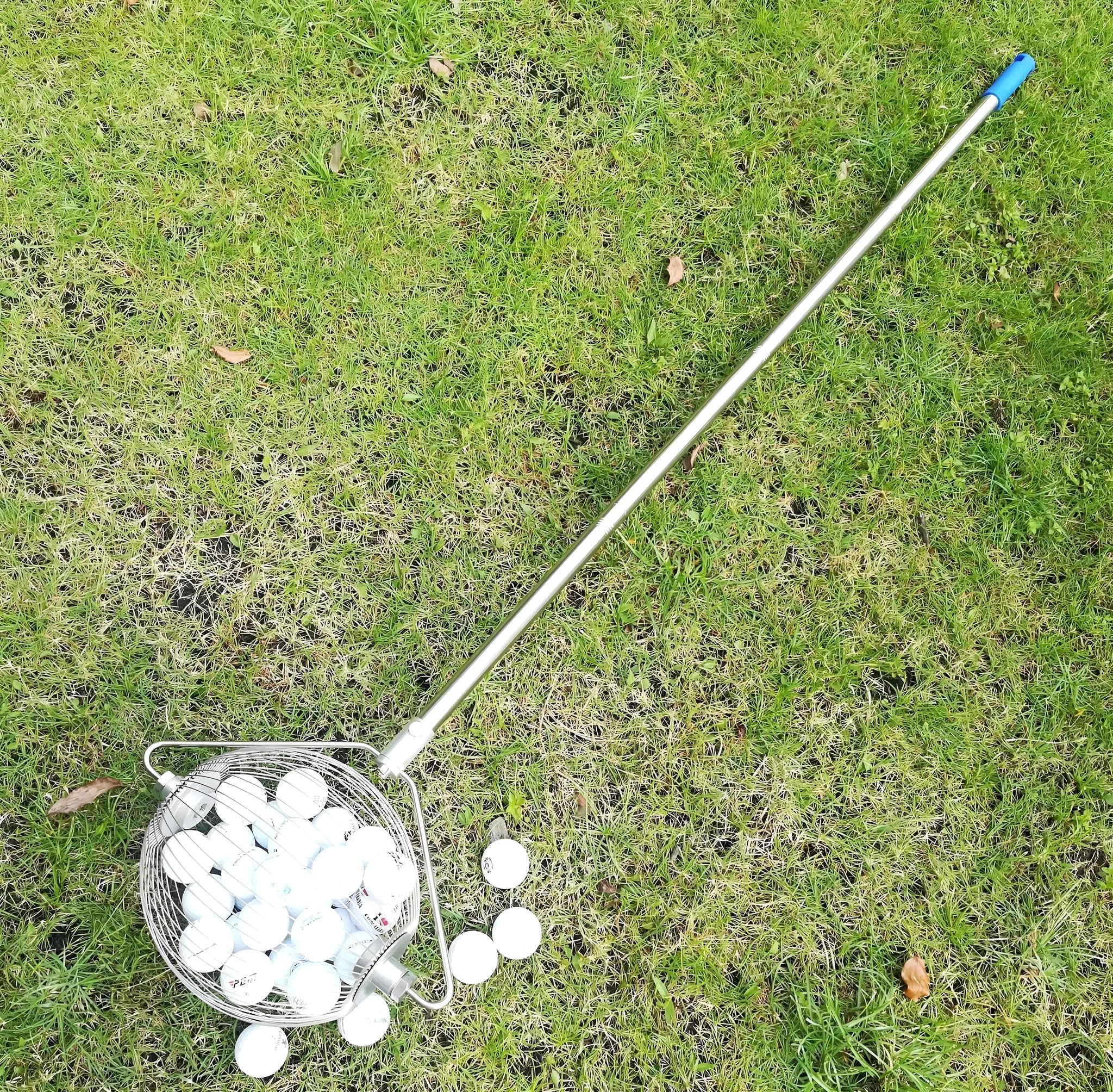Metallic coloured 304 stainless steel golf ball picker retriever on a green.