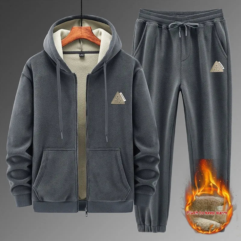 Man wearing a grey hooded zip-up sports jacket and matching trousers from a casual sports suit set.