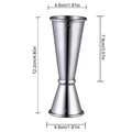 Double-headed stainless steel measuring cup and shaker on a bar counter for cocktail preparation