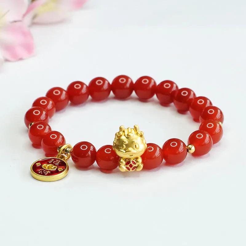 Close-up of a red agate beaded bracelet with a Chinese zodiac dragon charm on a wrist.
