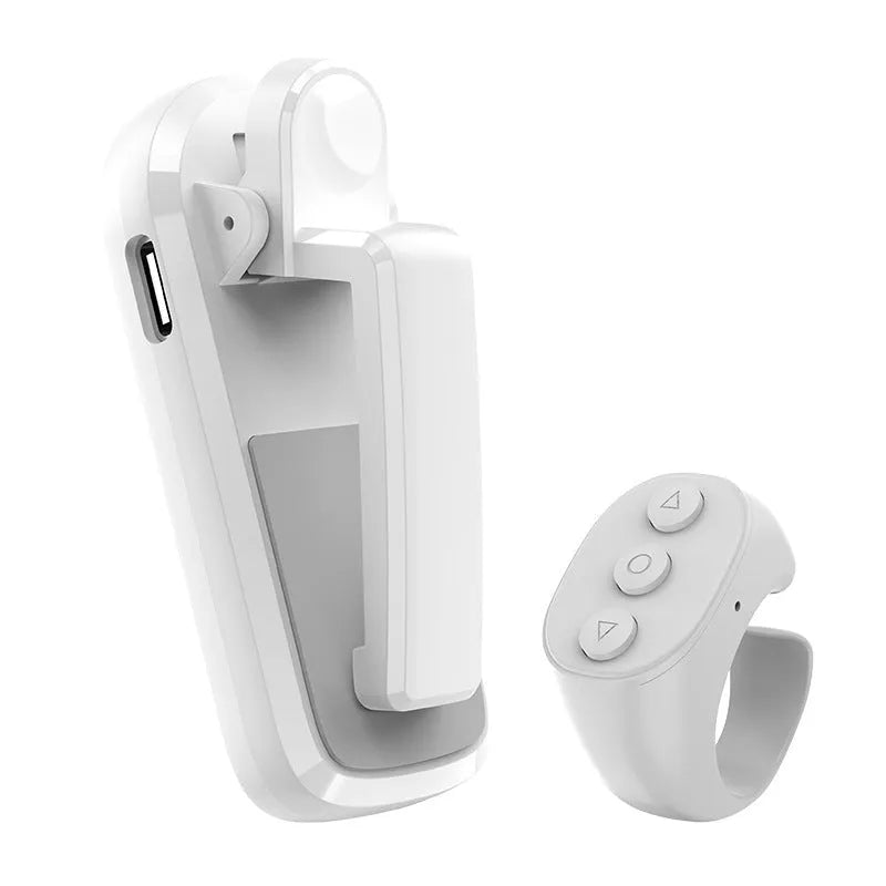 A black wireless page turner remote control and a separate clicker unit on a wooden desk.