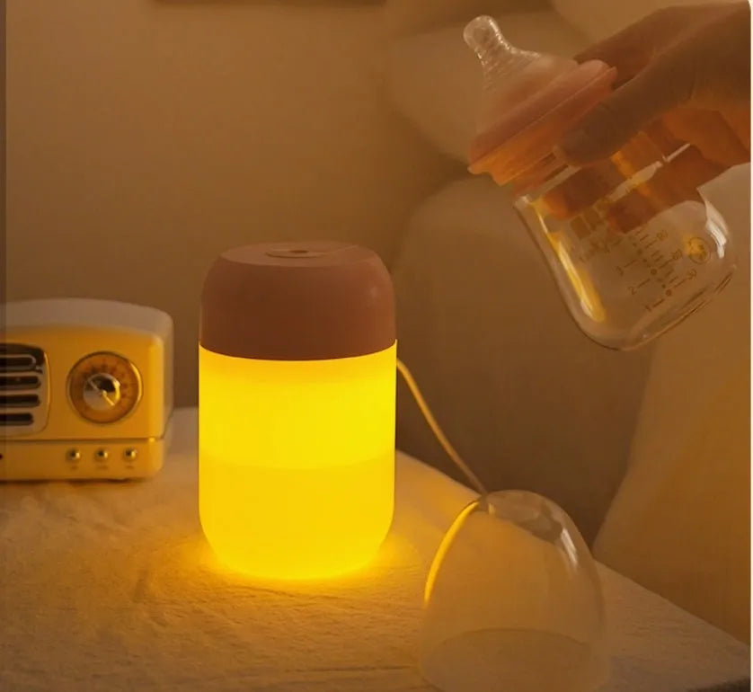 Small white cylindrical USB humidifier with aromatherapy function on a desk.