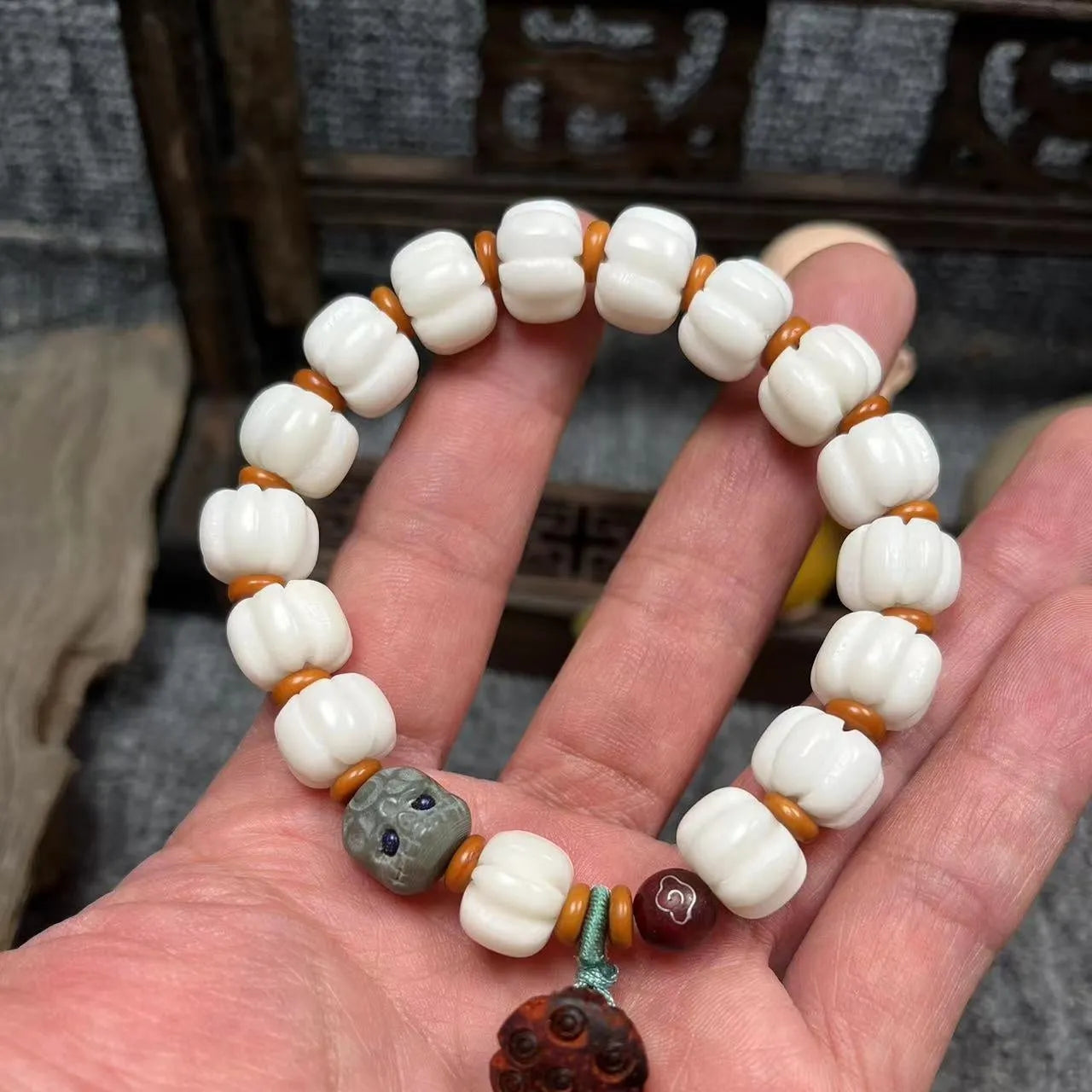 Carved pumpkin and lotus bead bracelet made from Bodhi root with white jade and aventurine details.
