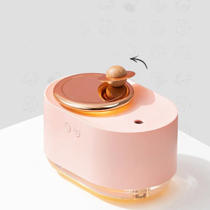 Green rotating planet USB portable humidifier with night light on a wooden desk.