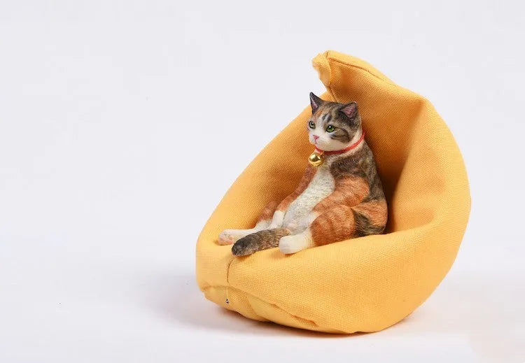 Small lazy cat car ornament and sofa, 7.5cm tall resin model on a car dashboard.