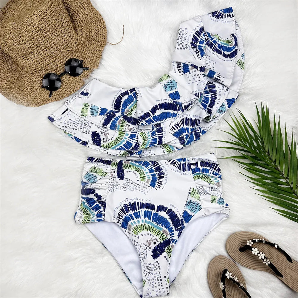 White women's one-shoulder bikini with a large lotus leaf ruffle and high-cut split leg briefs.