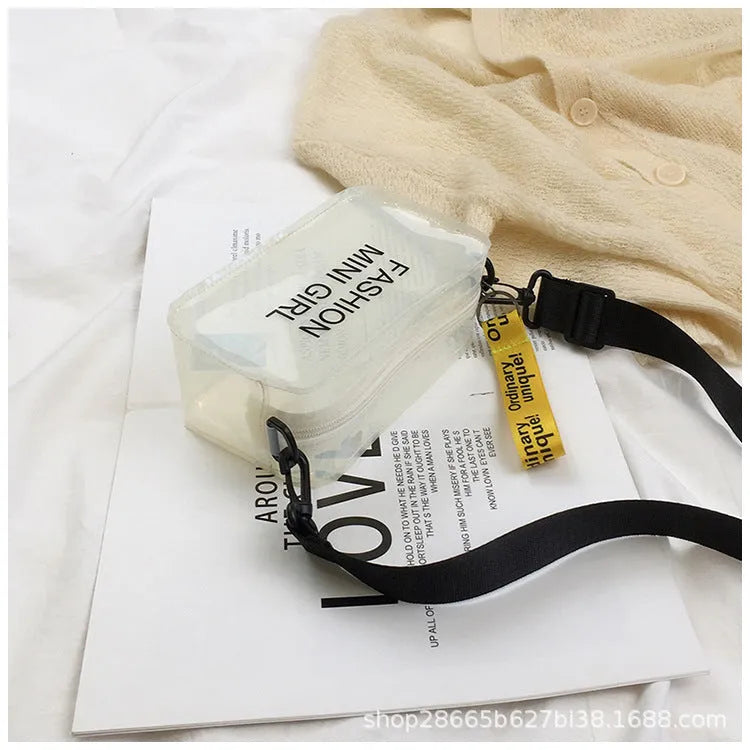 Transparent square women's shoulder bag in jelly material with a diagonal cross strap, showing internal mobile phone pocket.