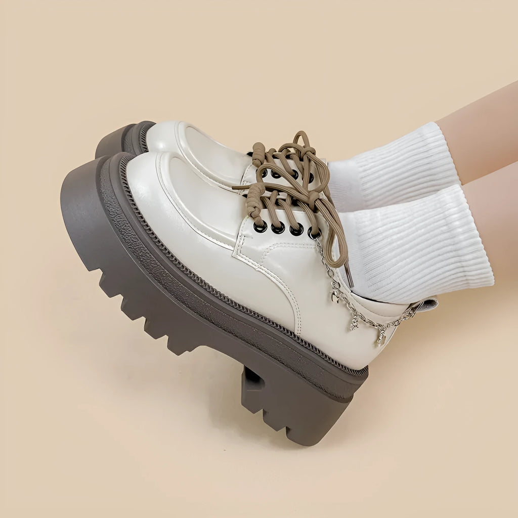 White platform Mary Jane shoes with chunky heel and front lace-up detail on a round toe.