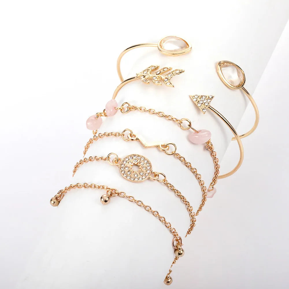 Gold-coloured women's bracelet set with six pieces showing spot drill arrow and water drop V-shaped charms