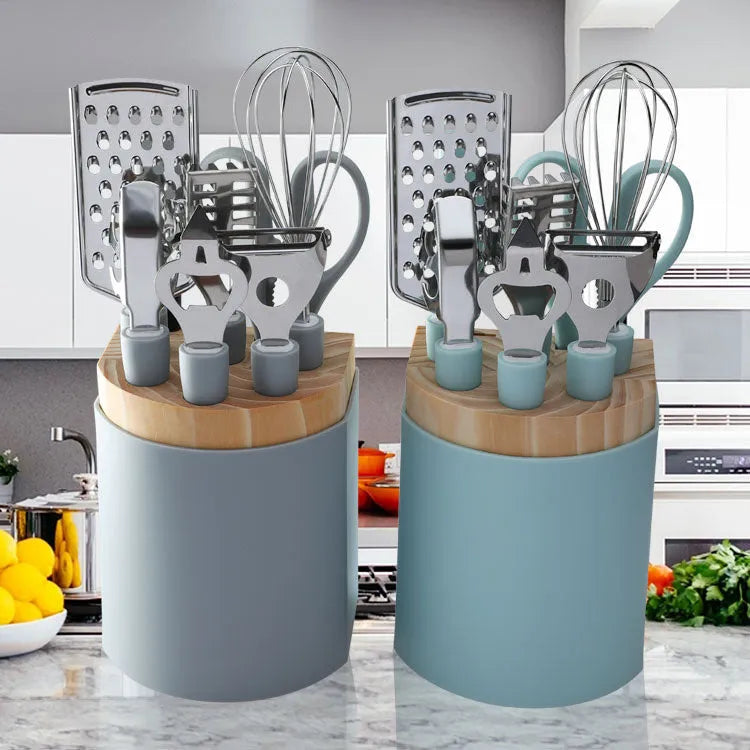 Stainless steel kitchen gadget set with whisk, grater, peeler, fruit knife, scissors, and tray lifter in grey