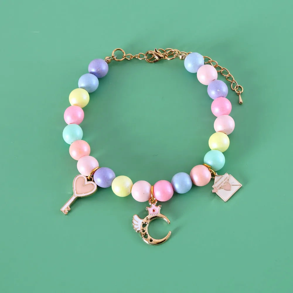 Colourful macaron charm pet collar and matching bracelet set in resin on a white background.