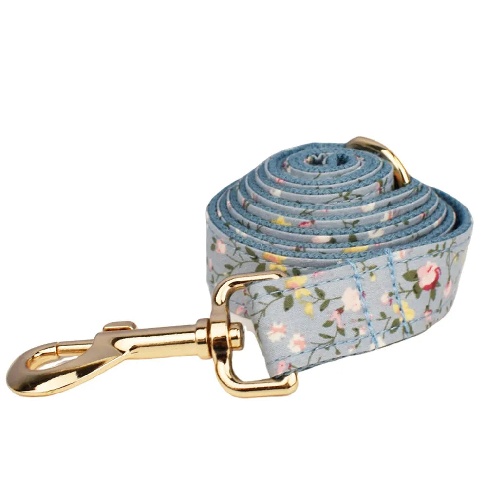 Blue floral pattern dog collar set with matching leash, bow, vest and waste bag dispenser accessories