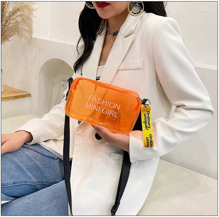 Transparent square women's shoulder bag in jelly material with a diagonal cross strap, showing internal mobile phone pocket.