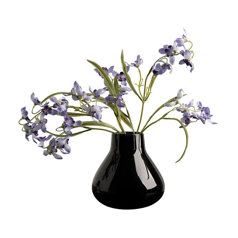 Ceramic decorative vase with coloured glaze surface and artificial orchid flowers in black or white colour