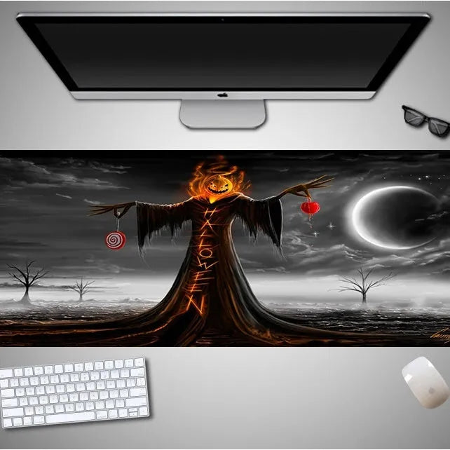 Oversized black Halloween-themed mouse pad with spooky artwork on a desk next to a gaming mouse.