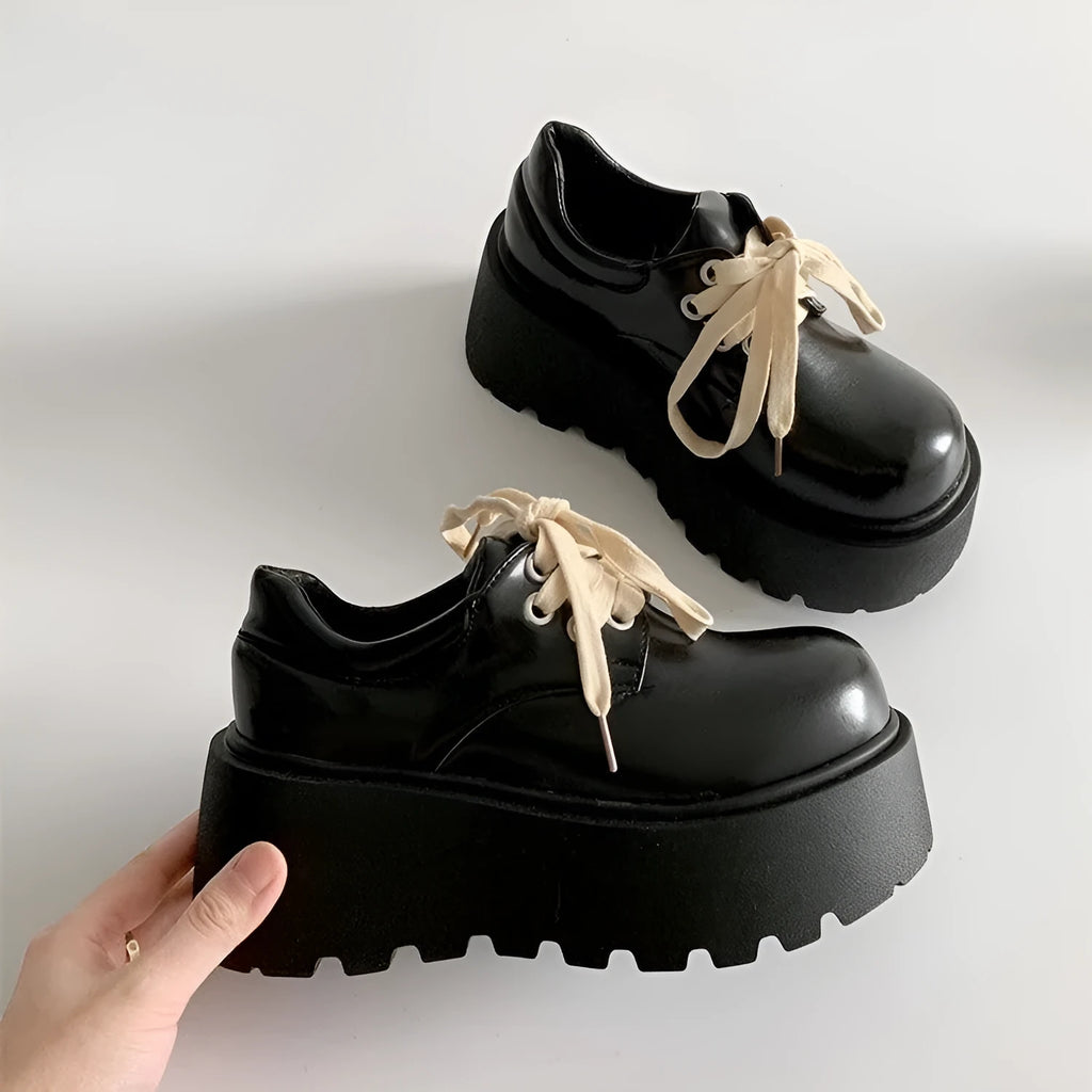 Black women's lace-up platform shoes with a chunky rubber sole and English muffin heel.