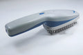 Pet comb with negative ion technology, removable brush head, and 9V battery compartment.