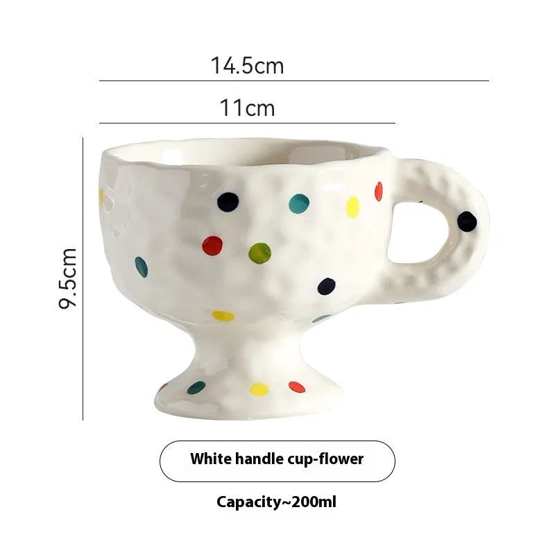 Hand-pinched irregular shaped ceramic mug in a solid colour on a table.