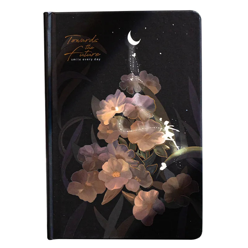 A5 notebook with luminous cover in deep blue, open to show lined pages with colour illustrations.