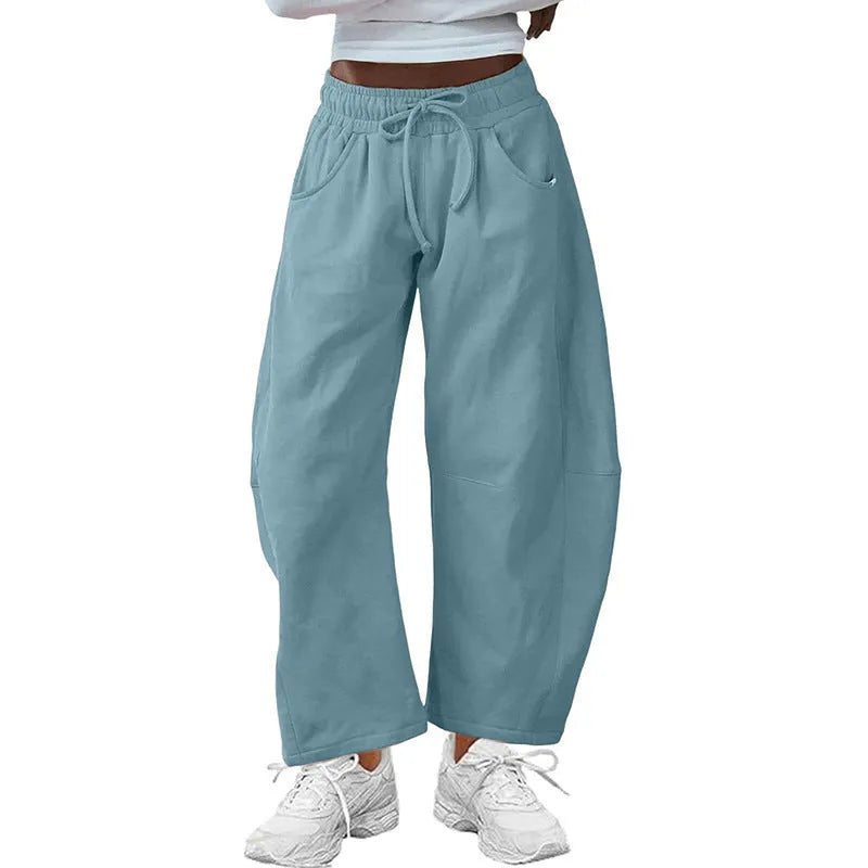 Loose grey cropped sweatpants with elastic drawstring waist and pockets on a mannequin