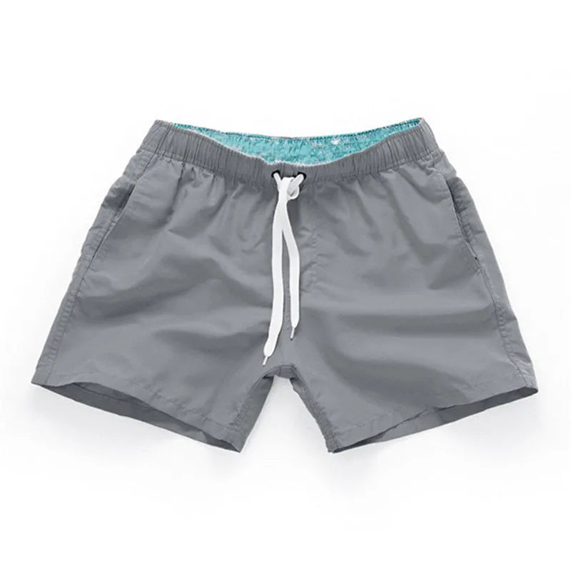 Men's straight-leg beach shorts in polyester, shown in a colour from the range including fluorescent yellow, black, or navy.