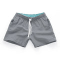 Men's straight-leg beach shorts in polyester, shown in a colour from the range including fluorescent yellow, black, or navy.