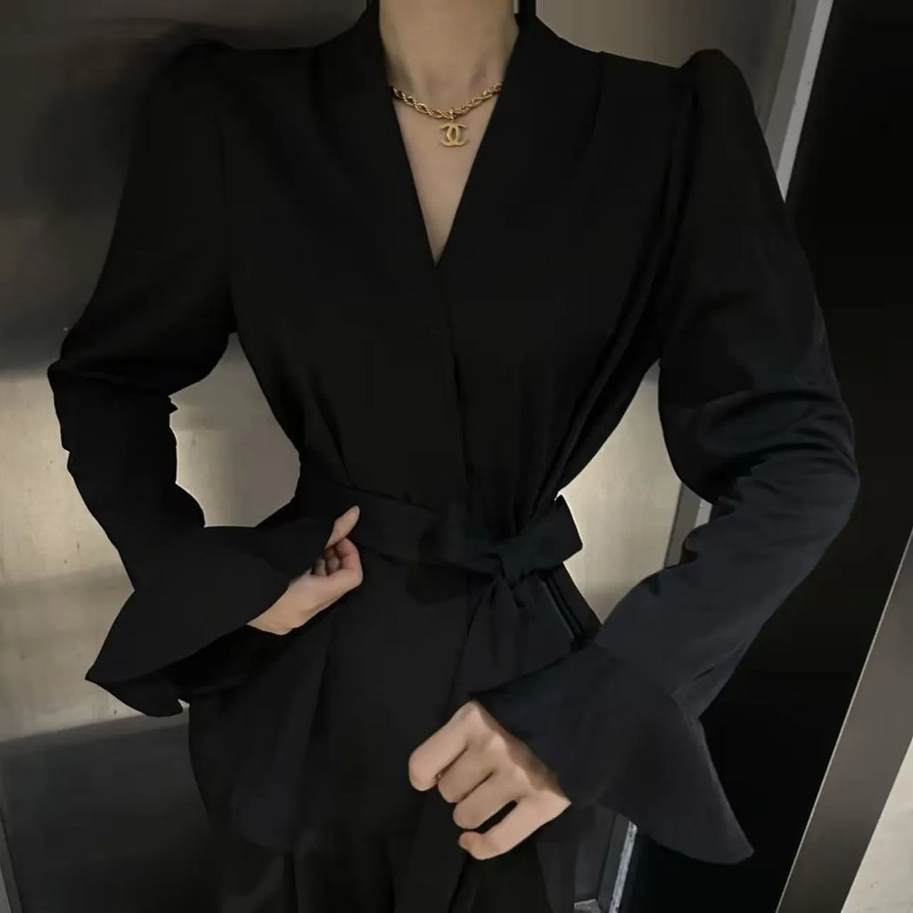 Women's black French-style shirt with irregular collar, long bell sleeves, and a front tie detail.