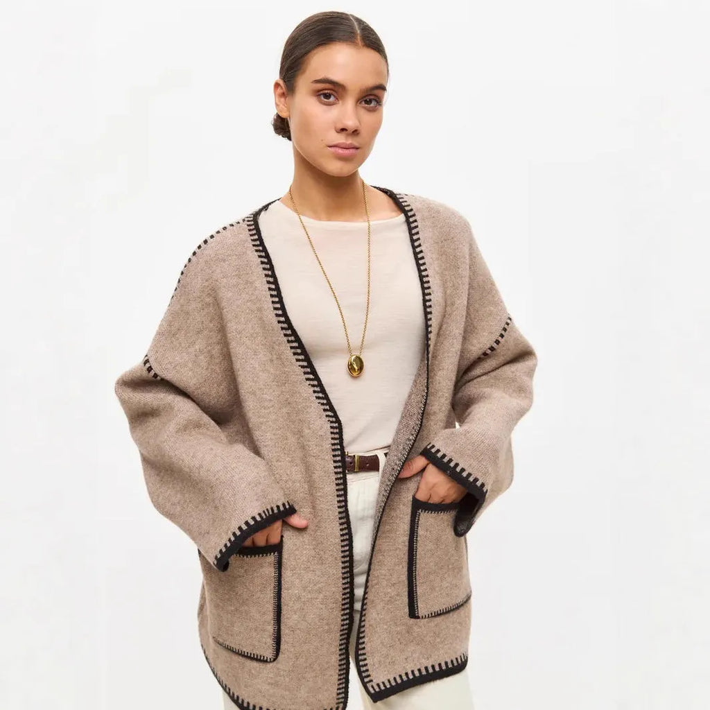 Loose fit camel coloured knitted cardigan sweater with long sleeves laid flat.