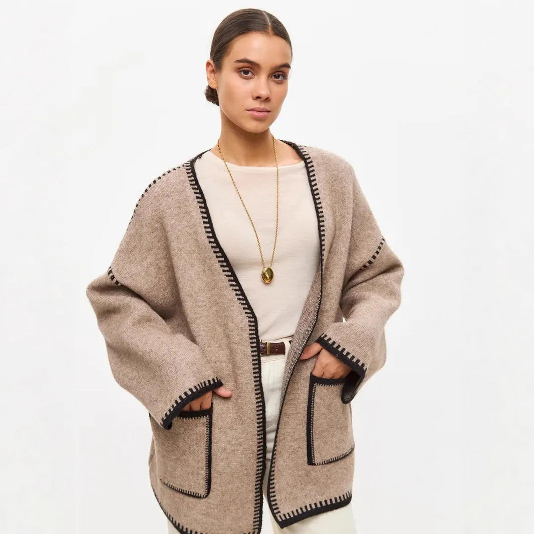 Loose fit camel coloured knitted cardigan sweater with long sleeves laid flat.