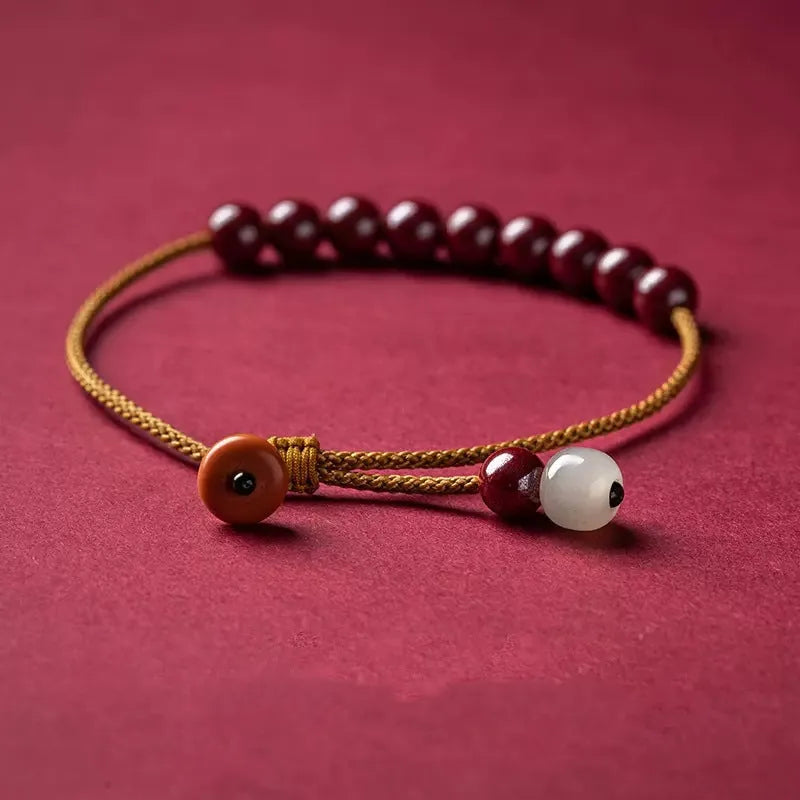 Hand-woven bracelet made from raw cinnabar ore and Hetian jade in a simple geometric shape.